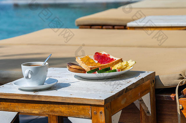 一杯带游泳池背景的咖啡、水果和<strong>蛋糕</strong>