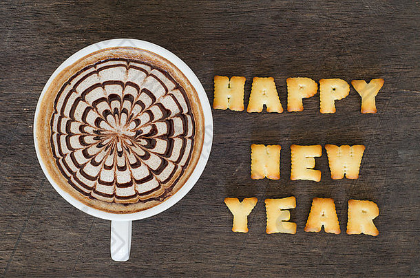 一杯用面包饼干做成的拿铁艺术和字母新年快乐