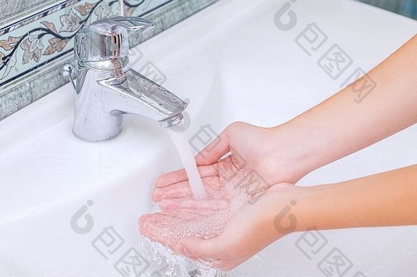 妇女在浴室用肥皂洗手和洗脸，以皮肤上的冠状病毒