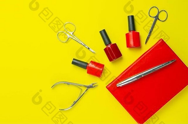 一套用于修甲和修脚的化妆工具。美甲剪刀、角质层、锯子、米勒和红色笔记本放在雅洛的背景上。俯视图