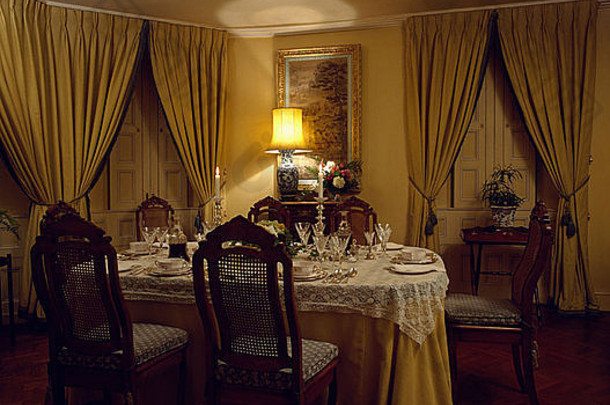 传统的餐厅有黄色的<strong>窗帘</strong>和桌布，房间一角有灯光