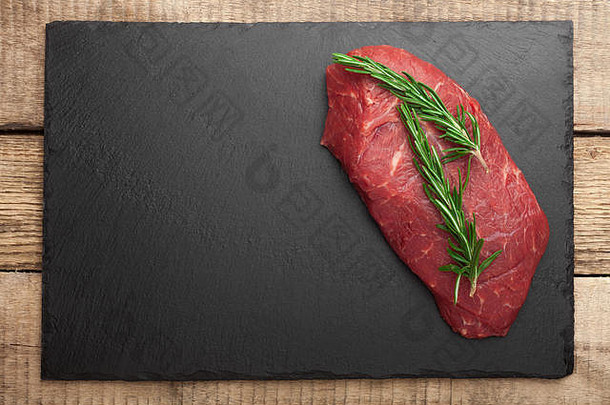 新鲜生肉配迷迭香黑石板，深色背景，牛排里贝耶