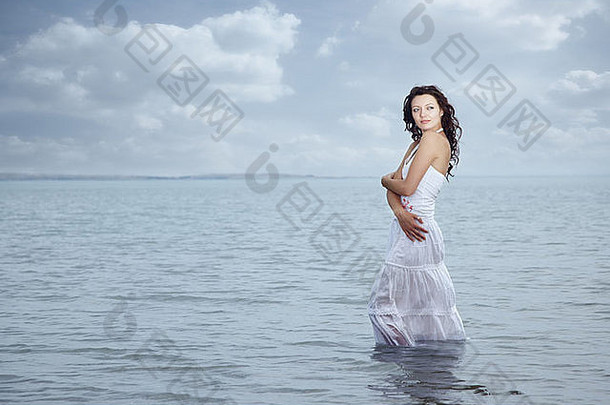 穿着湿裙子站在水里的女人