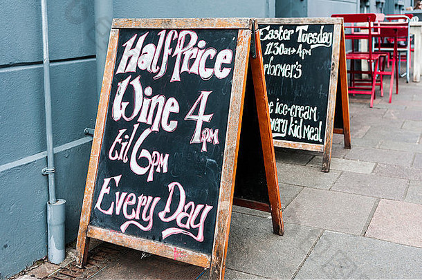 每天下午4点到6点，酒吧咖啡馆外的黑板上贴着半价葡萄<strong>酒广告</strong>。