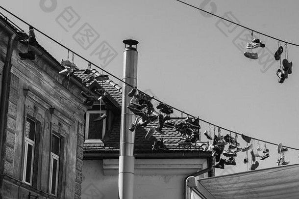 斯洛文尼亚卢布尔雅那挂在电线上的鞋子黑白照片