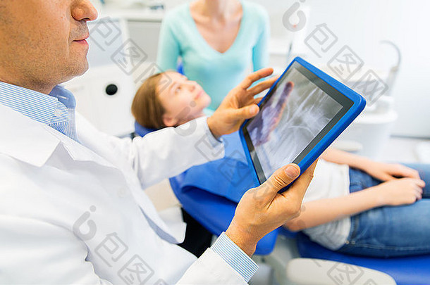 牙科医生在平板电脑上与女患者一起进行x光检查
