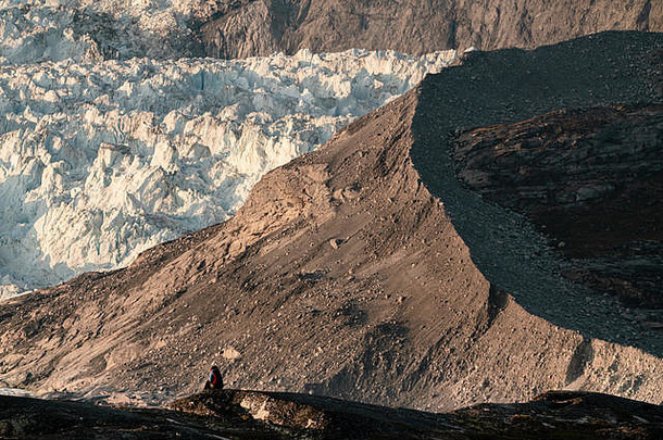 人们坐在巨大的冰墙前。Eqip Sermia冰川格陵兰岛的Eqi冰川在<strong>午夜</strong>被称为冰川崩解