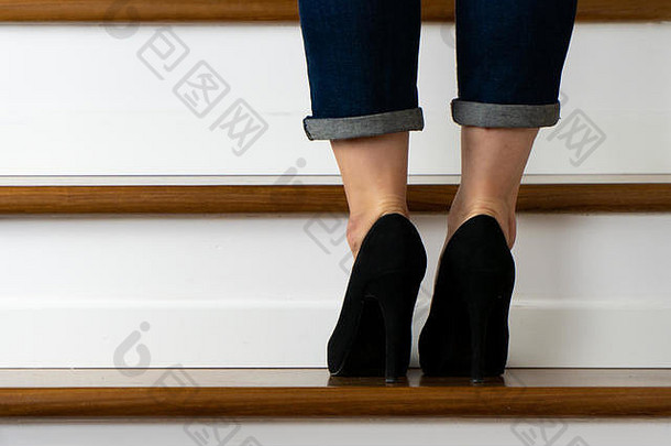穿着高跟鞋和牛仔裤上<strong>楼梯</strong>的女孩