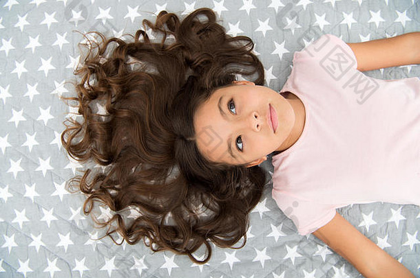 女孩孩子长卷曲的头发躺床上前视图孩子完美的卷曲的发型可爱的护发<strong>素面</strong>具有机石油头发闪亮的健康的令人惊异的卷发提示使卷曲的自然
