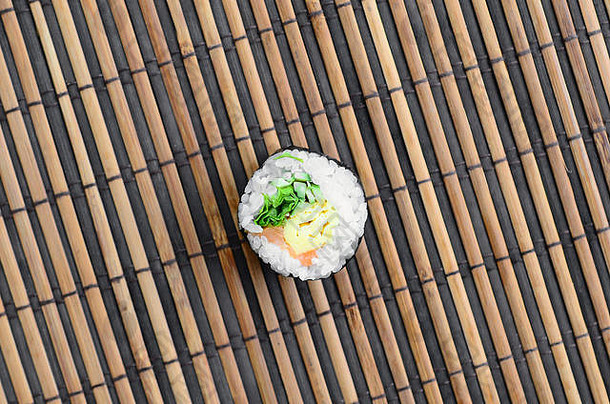 寿司卷躺在一块竹草席上。传统的亚洲食物。顶视图。平铺极简主义拍摄，带有空间。