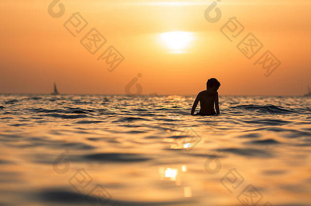 <strong>冲浪</strong>者在日落背景下在海洋或海洋中的轮廓