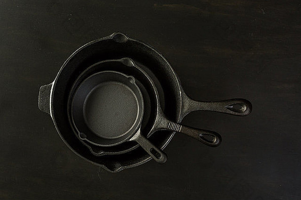 黑木桌上的传统铸铁<strong>煎锅</strong>。