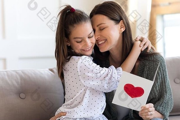 漂亮的女孩拥抱妈妈。祝贺展示问候卡