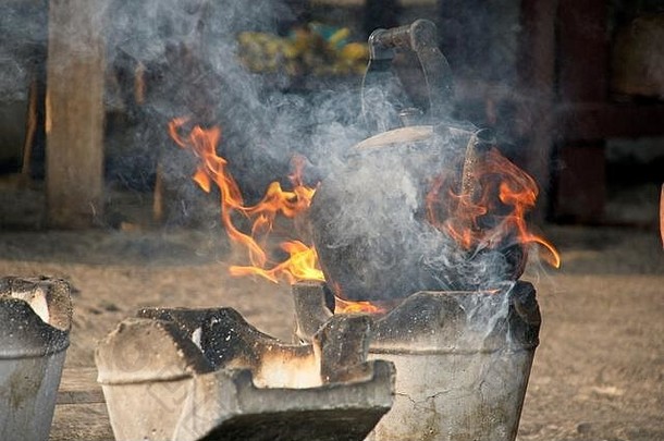 古老的黑烟壶盖在木火上的火焰上。