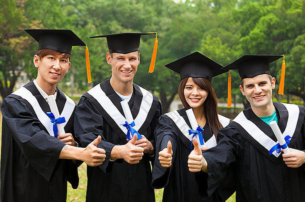 穿着毕业礼服、竖起大拇指展示毕业证书的快乐学生