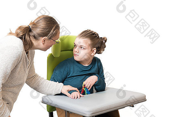 一名<strong>残疾儿童</strong>坐在轮椅上，由一名志愿护理人员照料