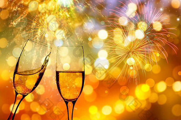 在烟花和节日灯光的映衬下配上香槟的玻璃杯——庆祝新年