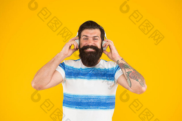 夏<strong>季</strong>播放列表。<strong>暑假</strong>音乐。<strong>暑假</strong>穿条纹衬衫的家伙。放松的旋律。留着胡子、留着长胡子、戴着黄色背景的耳机听歌曲的男人。