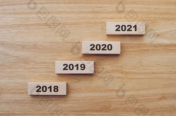 2018年至2020年，木桌背景上的木块新年快乐。新年概念