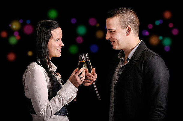 一对年轻夫妇正在喝酒。黑色背景