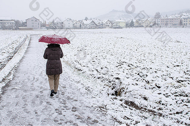 女人红色的伞漫步雪