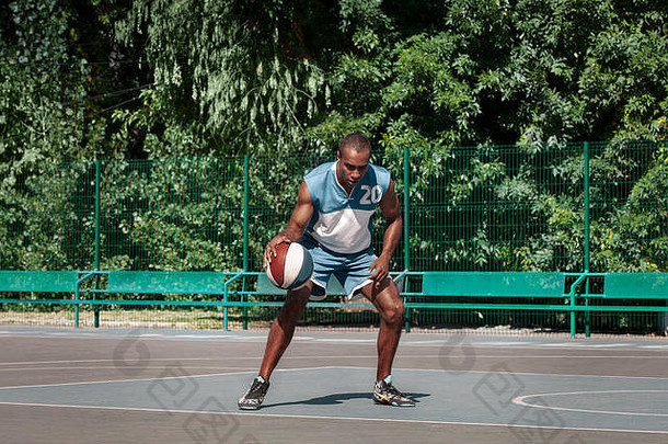 年轻困惑的非洲篮球运动员在户外练习的照片。让非洲男人运动<strong>自如</strong>。运动和运动生活方式概念