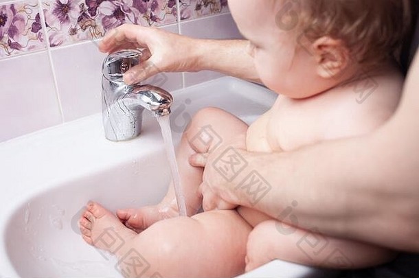 孩子在水槽里洗手。从水龙头喷出的水。用水消毒双手。<strong>病毒防护</strong>。洗手、卫生的概念。<strong>冠状病毒</strong>c