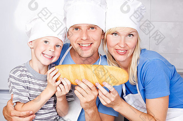 年轻的家庭；父亲、母亲和他们五岁的儿子在家里的厨房里一起吃面包