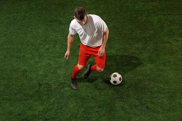足球球员解决球绿色草背景专业足球足球球员运动工作室适合跳男人。行动跳运动游戏