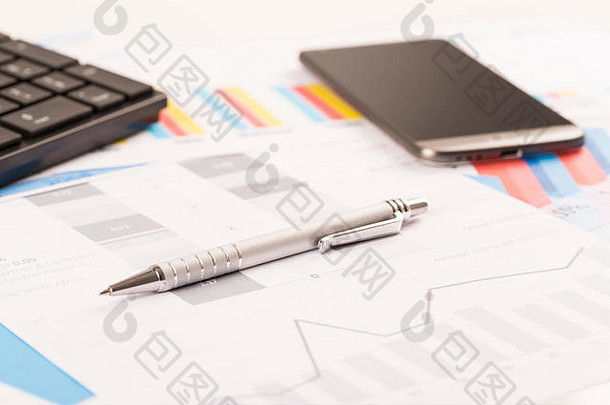 财务打印纸质图表，桌上的图表，带笔、手机、电话和键盘