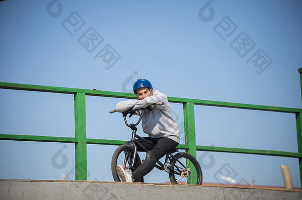 一个戴头盔的人骑在自行车的半管顶上