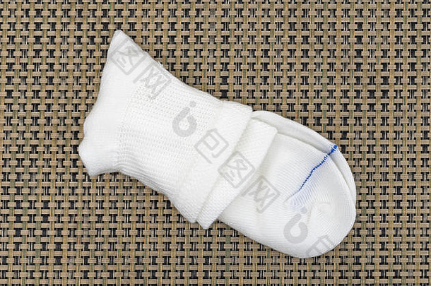 一双<strong>折叠</strong>在垫子上的糖尿病袜子。