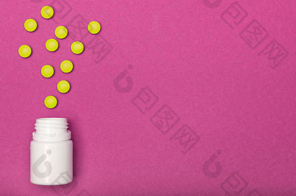 药瓶和黄色药丸洒在亮粉色的背景上。药物和处方药平铺背景。类流行病。