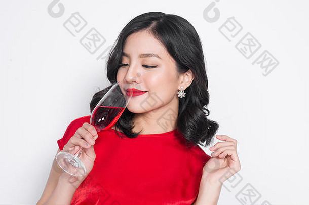 美丽的亚洲女孩穿着晚礼服，微笑着端着一杯香槟