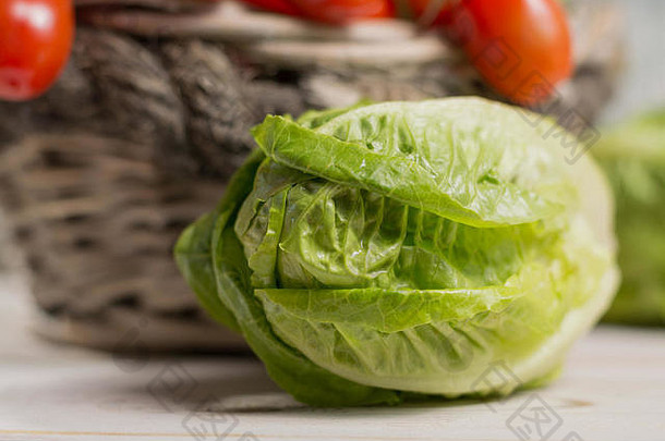 新鲜春季健康蔬菜沙拉的原料。绿色新鲜罗马生菜沙拉叶和罗马迷你西红柿——健康的低热量食品