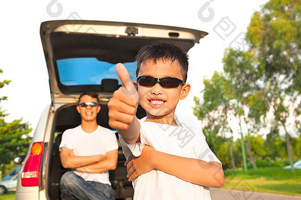 酷男孩竖起大拇指，爸爸抱着车