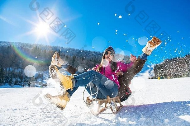 年轻的快乐夫妇滑雪橇冬天滑雪中心