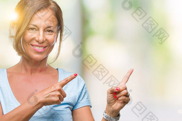 中间年龄高级拉美裔女人孤立的背景微笑相机指出手手指一边