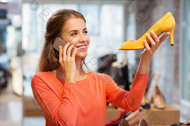 年轻的女人调用智能手机鞋商店