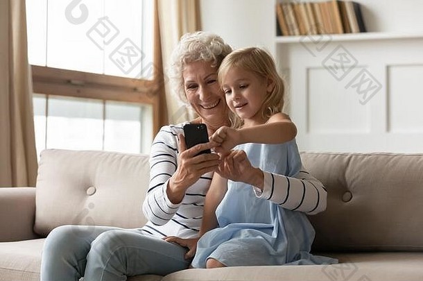 中间岁的女人智能手机可爱的孩子女孩