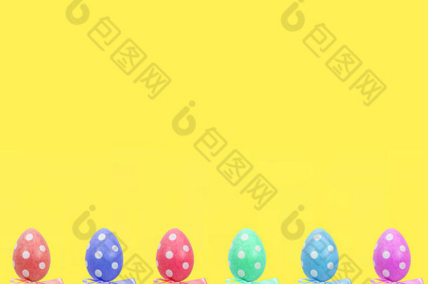 色彩斑斓的复活节鸡蛋前面黄色的背景