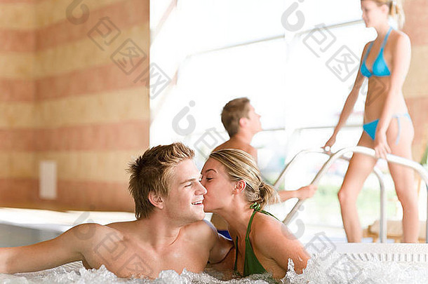 游泳池年轻的有吸引力的夫妇放松热浴缸