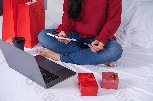 女人购物在线圣诞节礼物数字平板电脑信贷卡床上