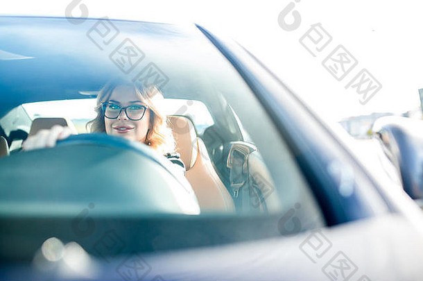 照片年轻的女人眼镜开车黑色的车