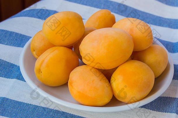 新鲜的成熟的杏子白色碗条纹布