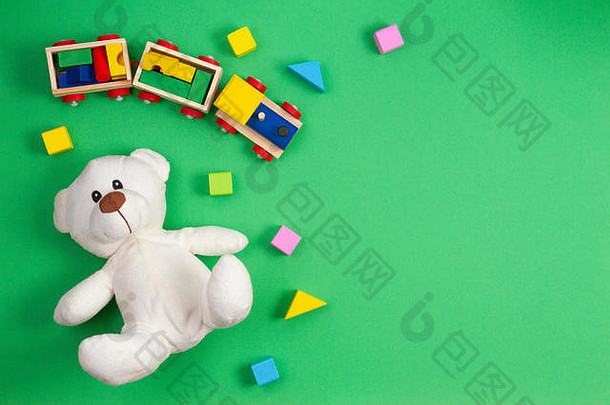 婴儿孩子们玩具背景白色泰迪熊木玩具<strong>火车</strong>色彩斑斓的块绿色背景前视图平躺