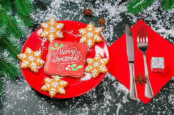 漂亮的铺设圣诞节表格姜饼饼干红色的板餐具刀叉快乐圣诞节