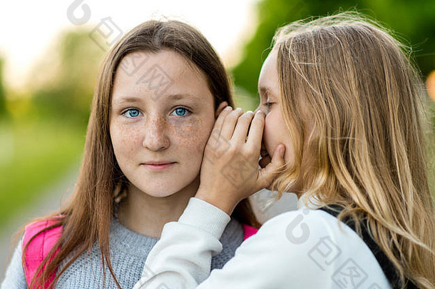 女孩女学生夏天公园自然低语耳朵概念秘密惊喜真理情绪微笑享受美丽的蓝色的gzal雀斑脸