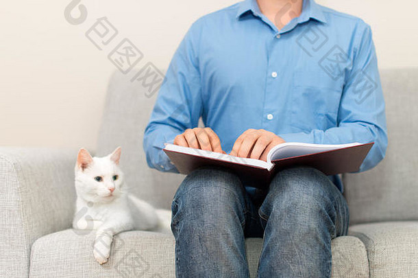 盲目的男人。阅读盲文书沙发上