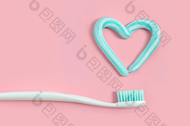 牙刷绿松石颜色牙膏形状心粉红色的背景牙科医疗保健概念